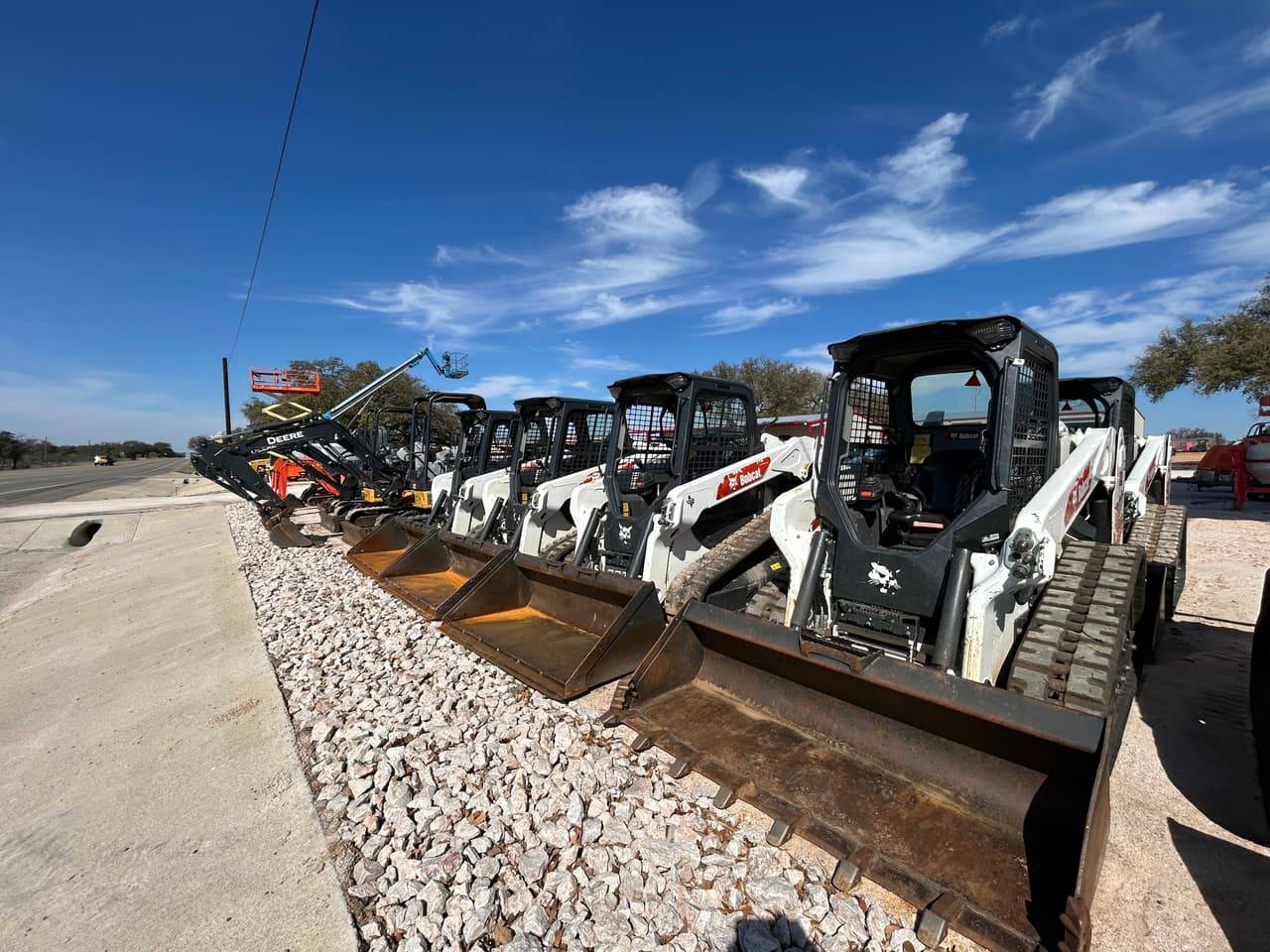 Row of Bobcat compact track loaders with John Deere mini excavators, a scissor lift and a boom lift available to rent at 4-T Rental & Sales on TX-29 in Buchanan Dam, TX