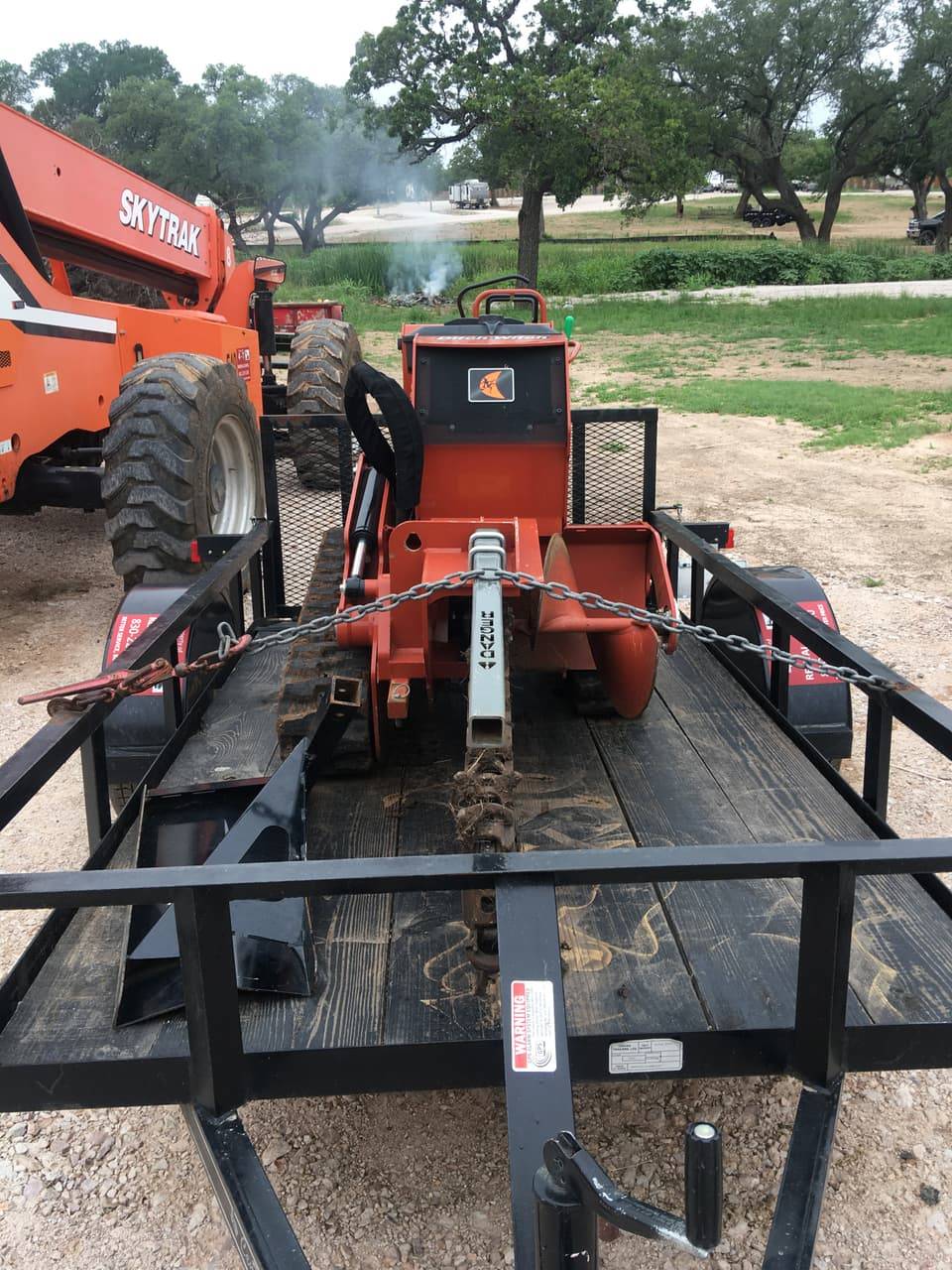 Ditch Witch track trencher chained to a trailer, front view
