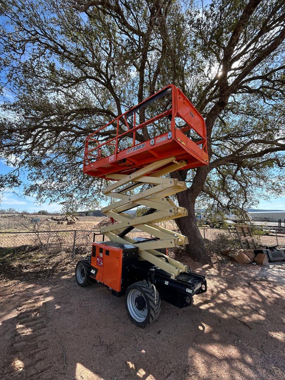 JLG RT3369 rough-terrain scissor lift with platform raised, available to rent in Buchanan Dam, TX